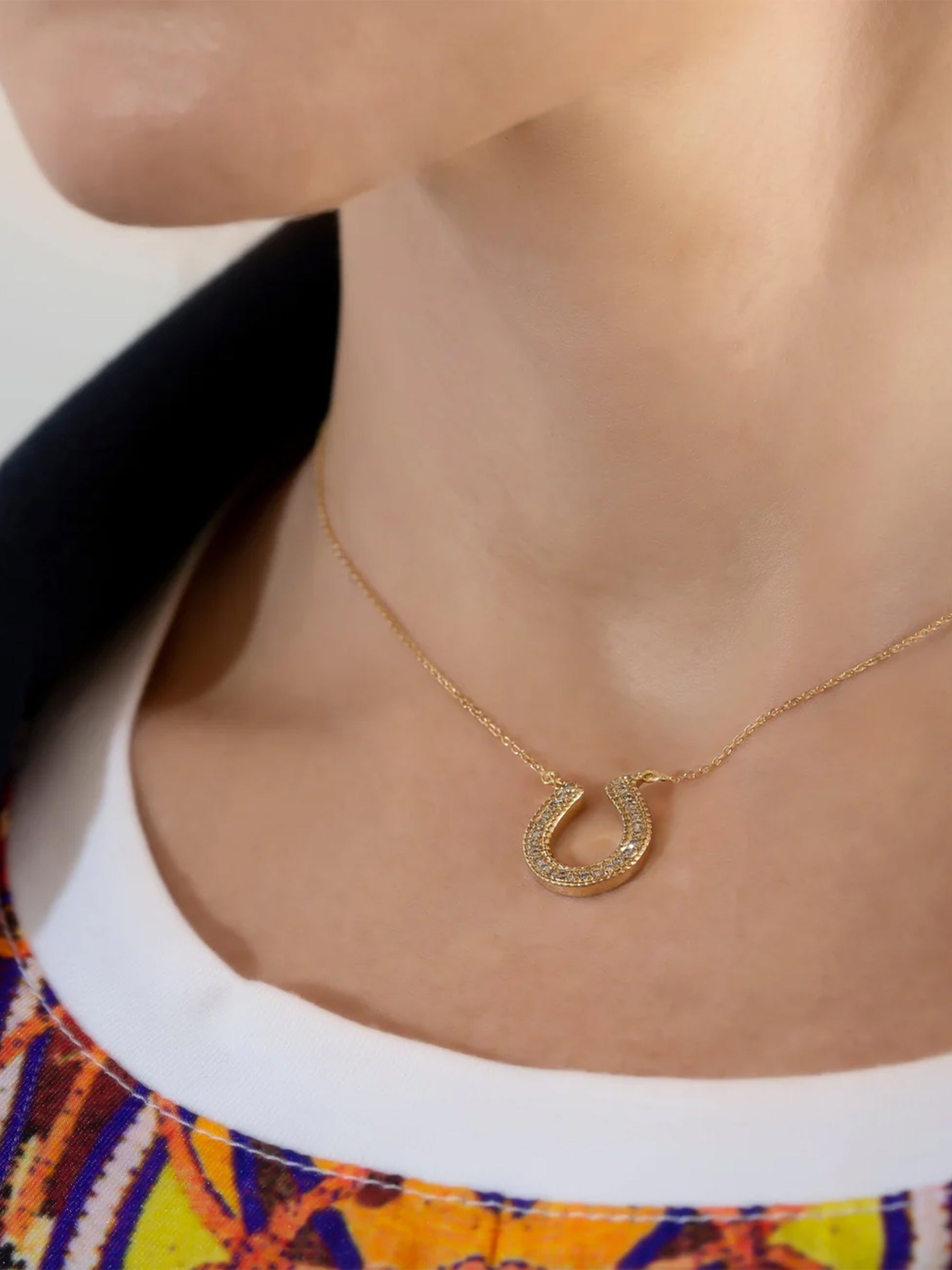 18k gold horseshoe necklace worn on model, minimal fine jewelry