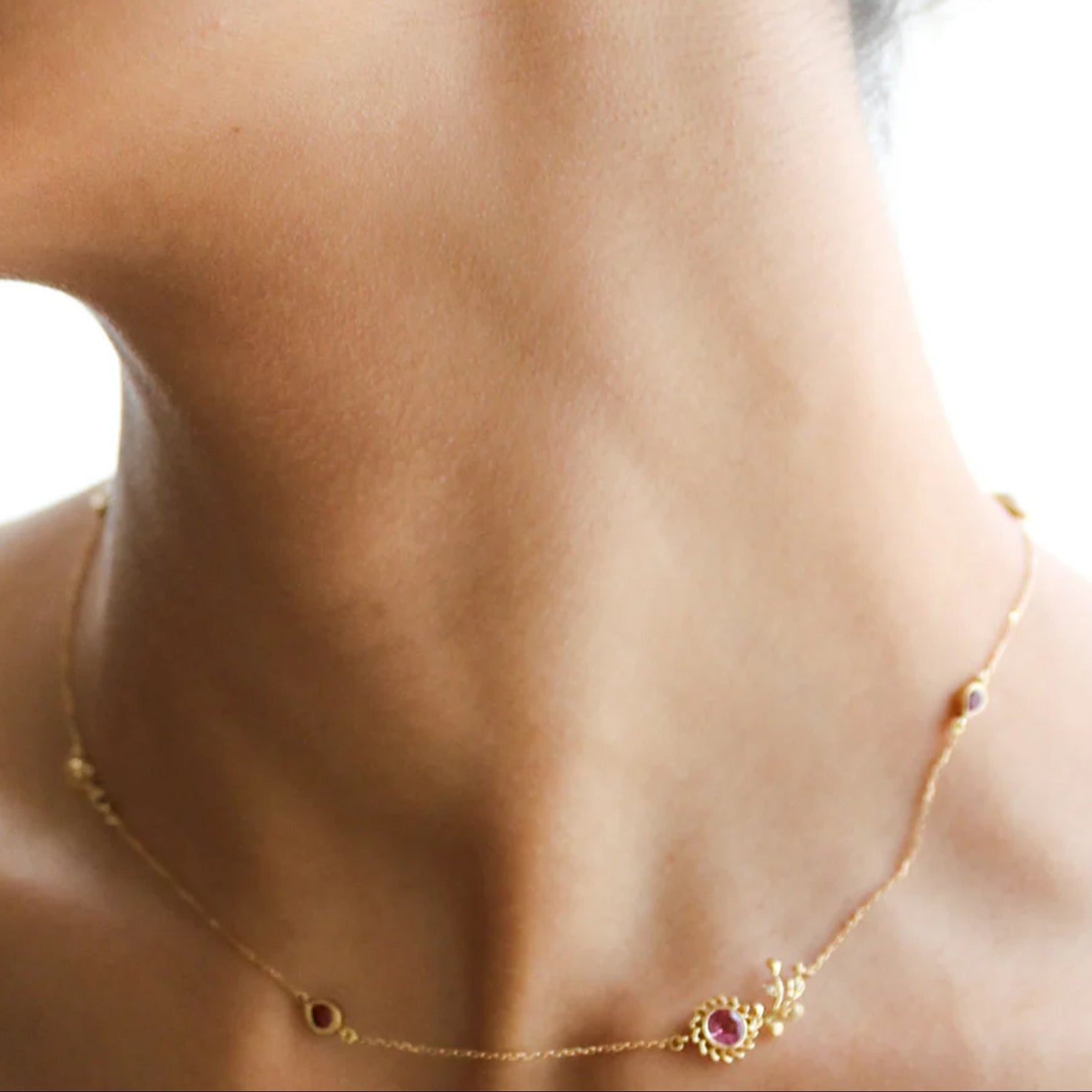 Close-up of a model wearing 18k gold aghabani lily viens necklace set with pink tourmaline and diamonds