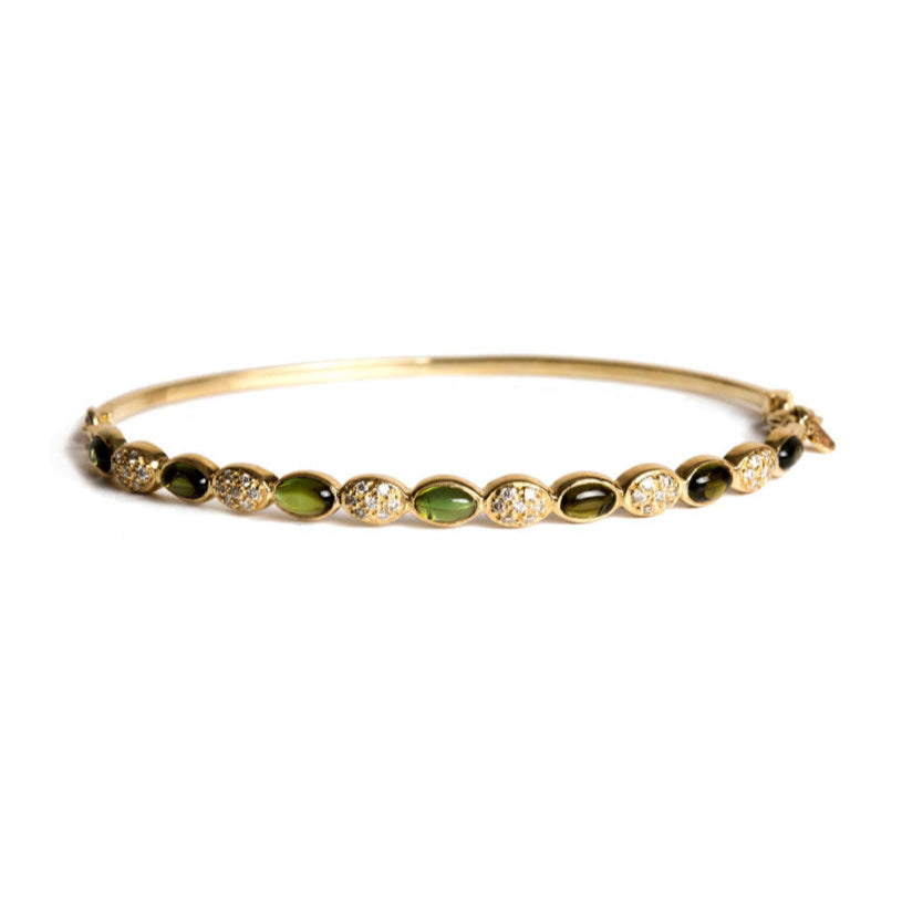 Close-up of gold Freestyle bracelet with oval green tourmalines and white diamond clusters on white background