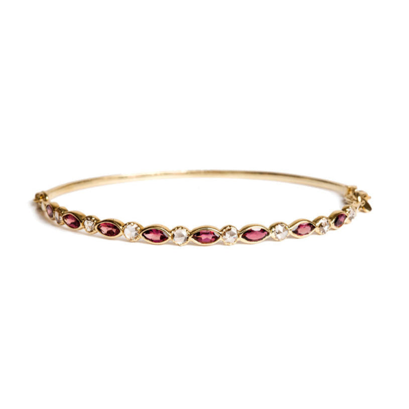 Gold bracelet with marquise pink tourmaline and rose cut diamonds on a white background