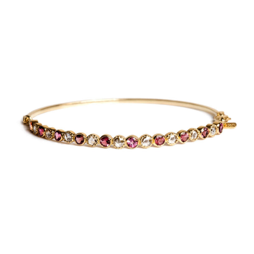 Close up Close-up of gold bracelet with pink round tourmaline and rose-cut diamonds on a white background