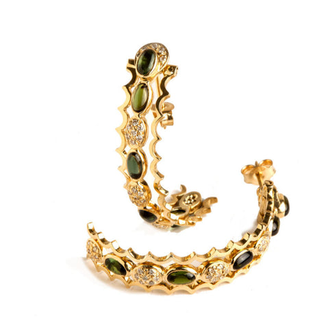 Close-up gold earrings with green tourmaline and diamonds on a white background.