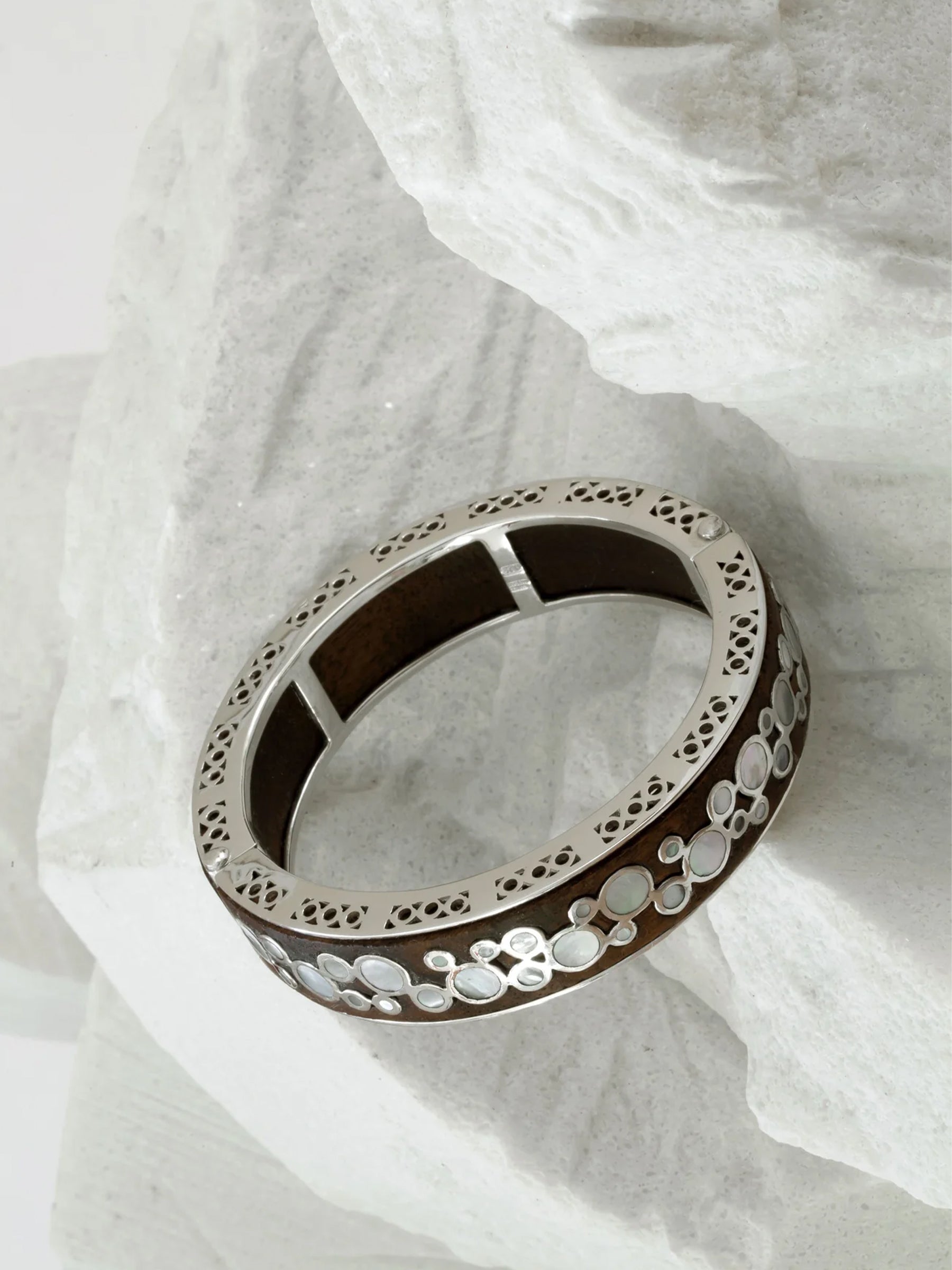 cleopetra mother of pearl bracelet in sterling silver with wood inlay, face-up on white marble showing fine details