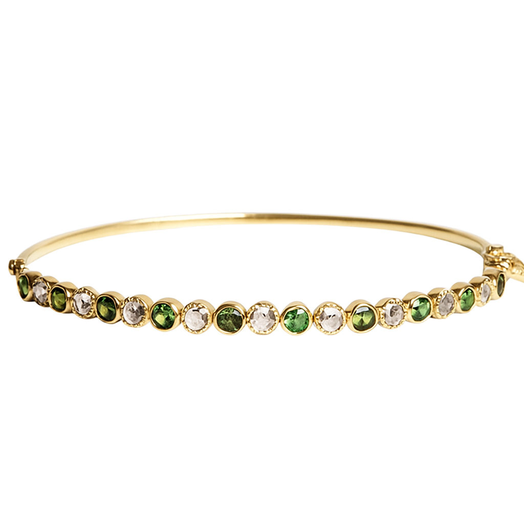 Close-up of an 18k gold bracelet with round green tourmaline and rose-cut diamonds on a white background.