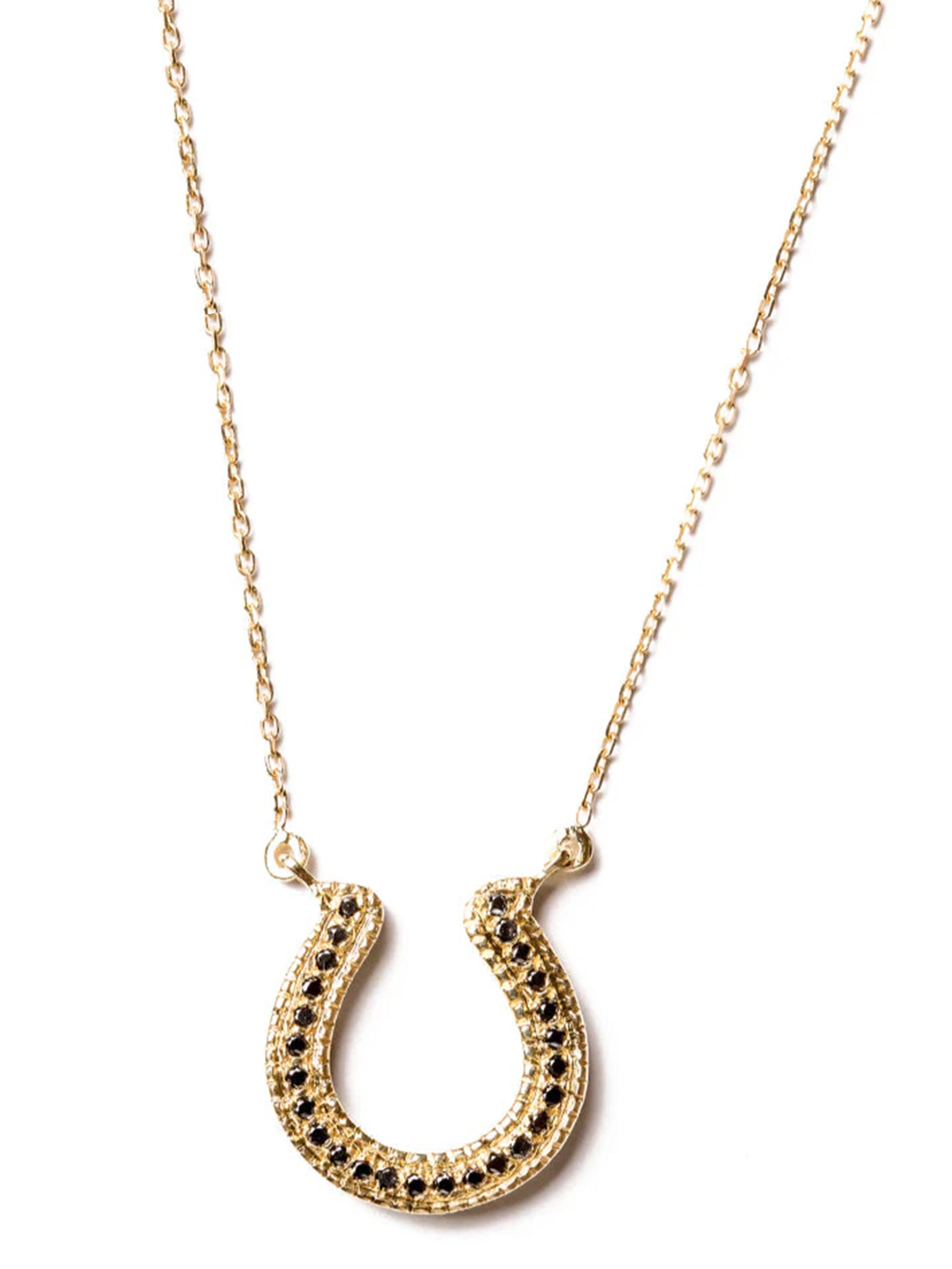 Handcrafted 18k gold horseshoe necklace with black diamonds on a fine chain, white background. 