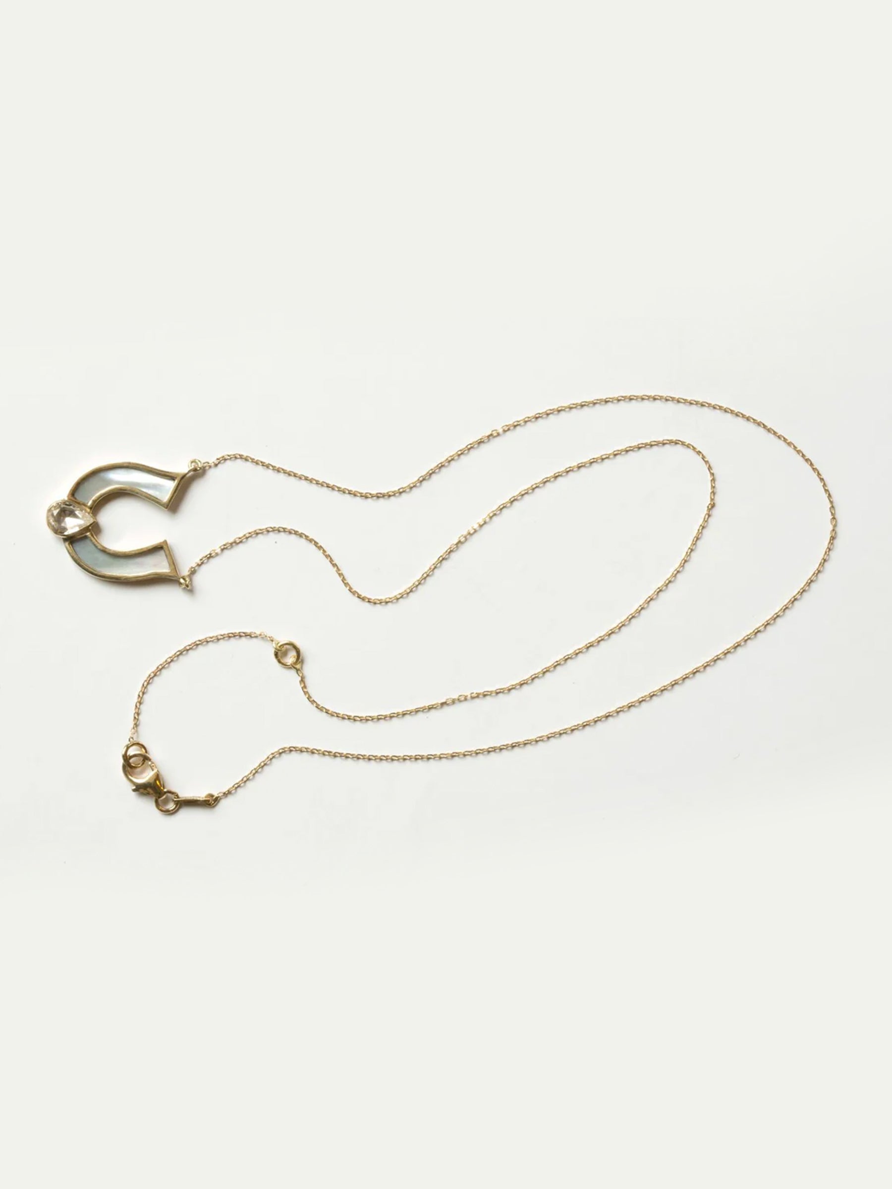 Horseshoe White Mother Of Pearl Necklace with white sapphire a close up image with the fine chain. 