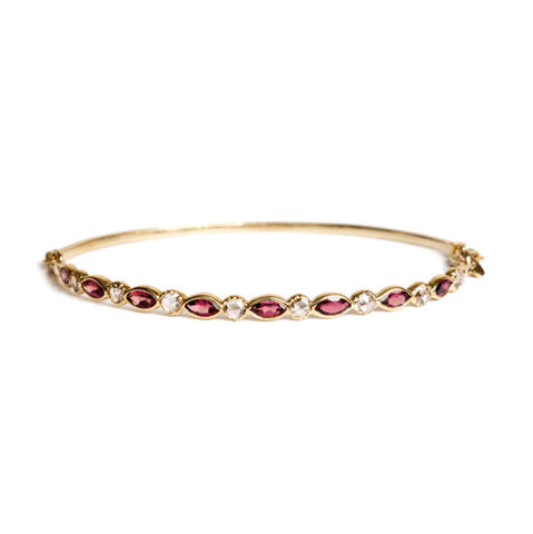 Gold bracelet with marquise pink tourmaline and rose cut diamonds on a white background